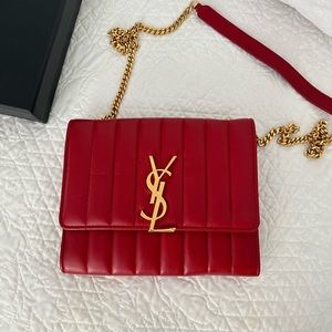 Yves Saint Laurent Red Vicky wallet on a chain with large gold YSL logo.